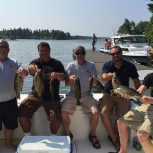 Fishing Trip with people holding up their catch on a boat